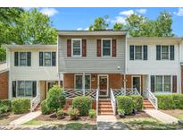 Charming townhouse with a brick facade, tidy landscaping, and a welcoming front porch in a residential setting at 4604 Townesbury Ln, Raleigh, NC 27612