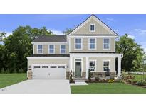 Charming two-story home featuring a welcoming porch and attached two-car garage at 47 Bluebell St, Sanford, NC 27330