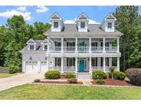 Stunning white two-story home with inviting front porch and beautifully landscaped yard at 513 Lake Gaston Dr, Fuquay Varina, NC 27526