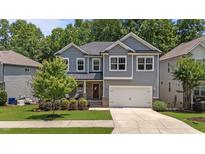 Charming two-story home features a manicured lawn, gray siding and a welcoming front porch at 516 Culmore Dr, Fuquay Varina, NC 27526