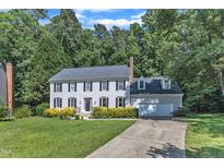 Traditional two-story home featuring gray siding, black shutters, and a well-manicured front lawn with mature trees at 6201 Bayswater Trail Trl, Raleigh, NC 27612