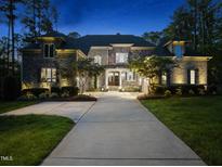 Stunning stone home exterior featuring elegant architectural details and a lush, landscaped yard at 7545 Hasentree Club Dr, Wake Forest, NC 27587