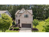 Two-story brick home featuring an attached garage and well-manicured front lawn at 8132 Wheeler Woods Dr, Apex, NC 27539