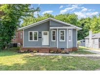 Charming gray home featuring a welcoming front porch and well-maintained lawn at 828 Cotton Pl, Raleigh, NC 27601