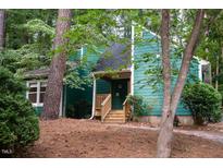 Charming home with green siding, wooden stairs to the front door, and mature trees at 90 Oak Leaf Ln, Chapel Hill, NC 27516