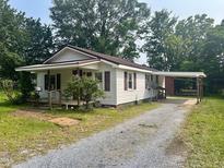 Cozy one-story home with a covered porch and a convenient carport, nestled among mature trees at 912 E Pope St, Dunn, NC 28334
