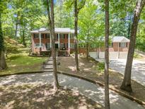 Beautiful brick home with a large yard, mature trees, and a long driveway leading to a three car garage at 9801 Honeycutt Rd, Raleigh, NC 27614