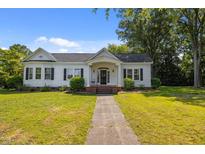 Charming one-story home with a well-manicured lawn, inviting front porch, and classic architectural details at 1000 College St, Oxford, NC 27565