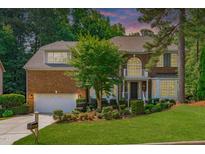 Stately brick home with lush landscaping, attached garage, and mature trees at 101 Quarryrock Rd, Holly Springs, NC 27540