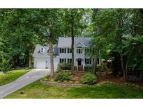 Charming two-story home featuring a manicured lawn, mature trees, and a two-car garage at 102 Turnberry Ln, Cary, NC 27518
