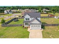 Charming two-story home with a manicured front lawn, two-car garage and fenced yard at 102 Williamson Place Dr, Princeton, NC 27569