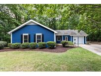 Charming blue home with lush green lawn and mature trees creating a serene outdoor space at 103 Summerlin Dr Dr, Chapel Hill, NC 27514