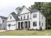 Charming two-story home with white siding, black framed windows, and a well-manicured lawn at 105 Everam Ct, Chapel Hill, NC 27516