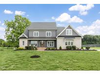 Stunning two-story home featuring a brick facade and beautiful manicured lawn and professional landscaping at 106 Garrison Farm Rd, Mebane, NC 27302
