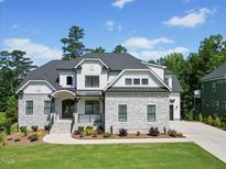 Beautiful two-story home featuring a stone and white facade, manicured lawn, and black window trim at 111 Stone Park Dr, Wake Forest, NC 27587