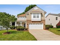 Charming two-story home with stone accents, a well-manicured lawn, and a two-car garage at 120 Ryder Cup Cir, Raleigh, NC 27603