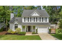 Charming two-story home with white siding, black shutters, and an attached two-car garage at 12117 Inglehurst Dr, Raleigh, NC 27613