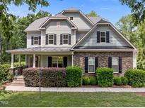 Charming two-story home with stone accents, black shutters, covered porch, and well-maintained landscaping at 12216 Kyle Abbey Ln, Raleigh, NC 27613