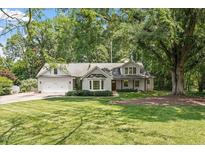 Charming single-story home featuring a manicured front lawn and attached two-car garage at 124 Lord Ashley Rd, Raleigh, NC 27610