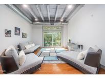 Bright living room with hardwood floors, modern furniture, and a sliding glass door to a balcony at 1300 St Marys St # 408, Raleigh, NC 27605