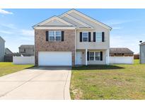 Charming two-story home with a brick front and a well-maintained front lawn at 131 Botanical Ct, Bunnlevel, NC 28323