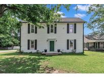 Charming two-story home with white siding, black shutters, and a well-maintained front yard at 141 S Broad E St, Angier, NC 27501