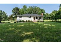 Charming single-story home featuring classic white siding, black shutters, and a lush green lawn at 1612 Bethlehem Rd, Knightdale, NC 27545