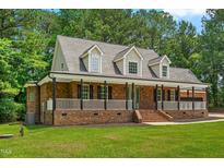 Charming brick home featuring a welcoming front porch with columns and dormer windows at 2015 Saddlebrook Dr, Archer Lodge, NC 27527