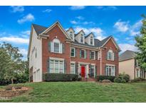 Charming two-story brick home with well-manicured landscaping and a vibrant red front door at 2224 Narrawood St, Raleigh, NC 27614