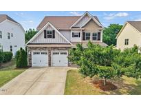 Charming two-story home featuring a two-car garage, stone accents, and manicured lawn at 2256 Toad Hollow Trl, Apex, NC 27502