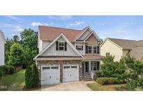 Charming two-story home with a stone facade, attached two-car garage, and beautifully landscaped front yard at 2256 Toad Hollow Trl, Apex, NC 27502