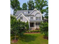 Beautiful two-story home with a manicured lawn, mature trees, and a welcoming front porch at 2661 Silver Bend Dr, Apex, NC 27539