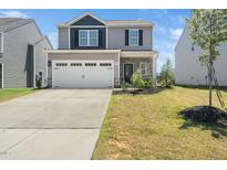 Charming two-story home with a two-car garage, stone accents, and a well-maintained front lawn at 304 Azalea Gaze Dr, Youngsville, NC 27596
