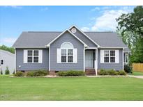 Charming single-story home with a well-maintained lawn, stylish gray siding, and white trim at 308 E Quailwood Dr, Fuquay Varina, NC 27526