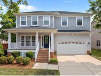 Charming two-story home featuring a welcoming front porch, attached two-car garage, and well-maintained landscaping at 324 Farrow Glen Loop, Cary, NC 27519