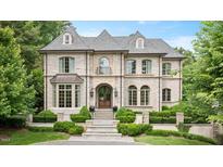 Elegant stone-clad home with manicured landscaping, arched windows, and a welcoming front entrance at 3347 Alamance Dr, Raleigh, NC 27609