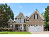 Charming two-story home with brick and siding, featuring a two-car garage and well-manicured lawn at 37 Meadow Oaks Cir, Smithfield, NC 27577