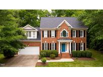 Beautiful two-story brick home featuring a blue front door and well-manicured landscaping at 3908 Sterling Ridge Ln, Durham, NC 27707
