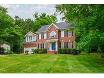 Charming two-story red brick home with a blue front door and well-manicured lawn at 3908 Sterling Ridge Ln, Durham, NC 27707