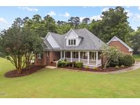 Inviting brick home with a well-manicured lawn and charming front porch at 3912 Kildrummy Dr, Durham, NC 27705