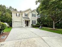 Charming two-story home featuring a garage and a beautifully patterned concrete driveway at 407 Elm Farm Pl, Morrisville, NC 27560