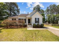 Charming one-story home with white siding, black shutters, and landscaped front yard at 408 Flagg Rd, Holly Springs, NC 27540