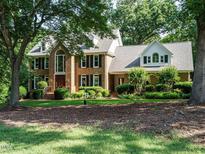 Beautiful brick home with lush landscaping and mature trees, offering great curb appeal at 4204 Thetford Rd, Durham, NC 27707