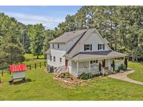 Charming two-story home featuring a welcoming front porch and lush green lawn at 4702 Pleasant Green Rd, Durham, NC 27705