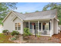Charming home with a cozy front porch, complete with hanging flower baskets and a well-manicured garden at 50 Rainwood Ct, Louisburg, NC 27549