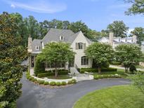 Stunning exterior of a white painted brick home with manicured landscaping and an asphalt driveway at 504 Yarmouth Rd, Raleigh, NC 27608