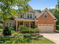 Beautiful brick home with manicured lawn, covered porch, and two-car garage at 5108 Briton Pl, Fuquay Varina, NC 27526