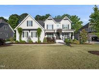 Stunning two-story home with manicured lawn and charming architectural details on a sunny day at 517 Myrna Ln, Wake Forest, NC 27587