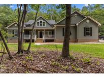 Charming exterior of home featuring neutral siding, complemented by lush trees surrounding the property at 5300 Langdon Dr, Oxford, NC 27565