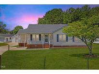 Charming single-story home featuring a well-manicured lawn, quaint front porch, and a detached garage at 5328 Trackway Dr, Knightdale, NC 27545